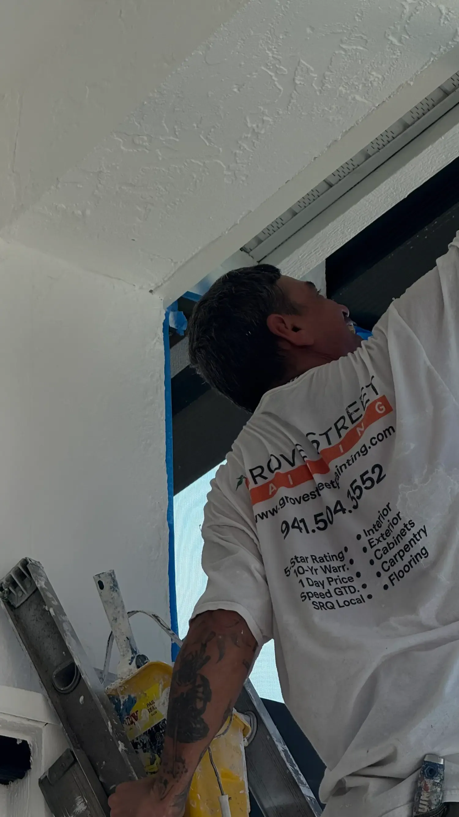 Grove Street Painting crew member on a ladder brushing exterior trim in Sarasota