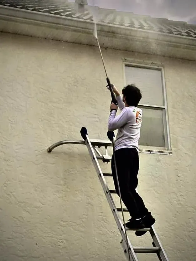 Grove Street Painting employee pressure washing soffits on a Sarasota home