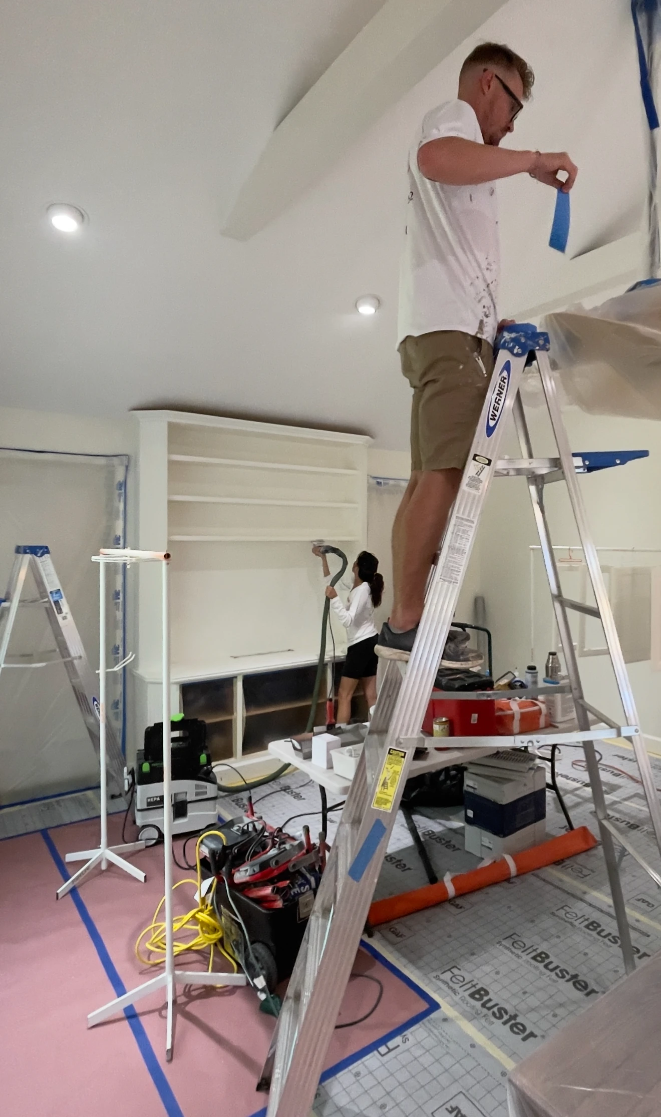 Sarasota painter working safely on ladder painting exterior trim