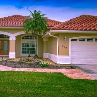 Exterior painting Sarasota - Waterfront stucco home with palm trees